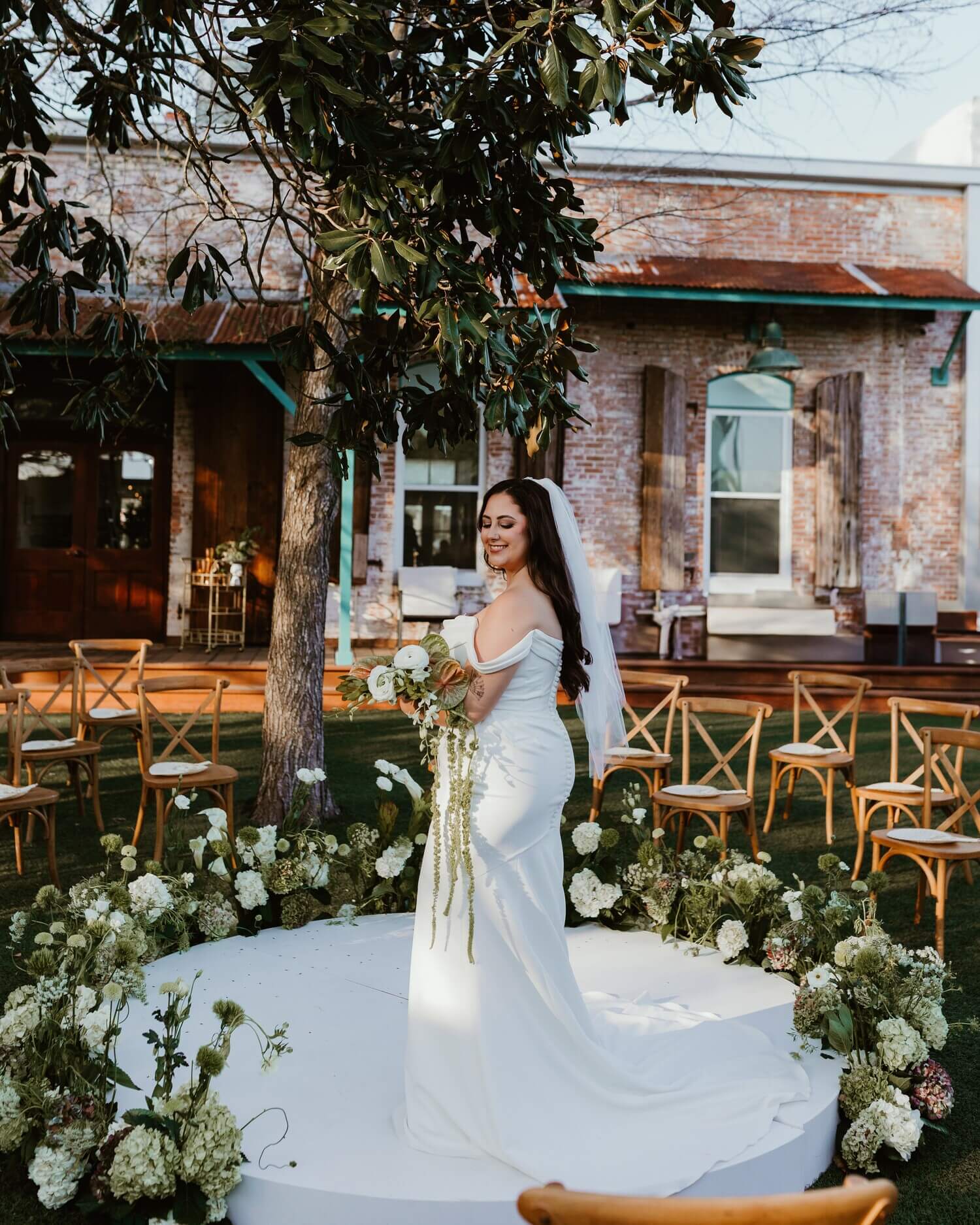 happy bride in middle of flower arrangement