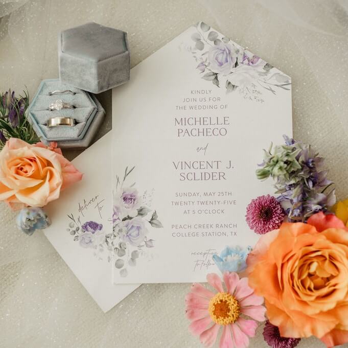 A showcase of the engagement ring and wedding invitation of Michelle Pacheco with colorful flowers as decorations.