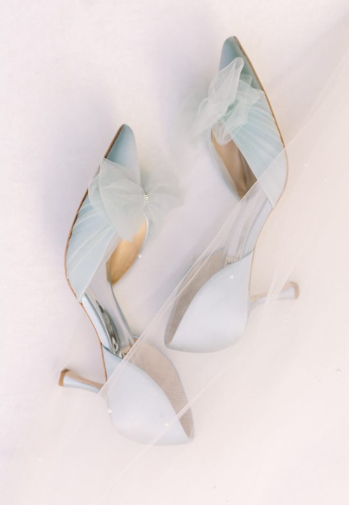 A pair of baby blue heels with tulle bow details.