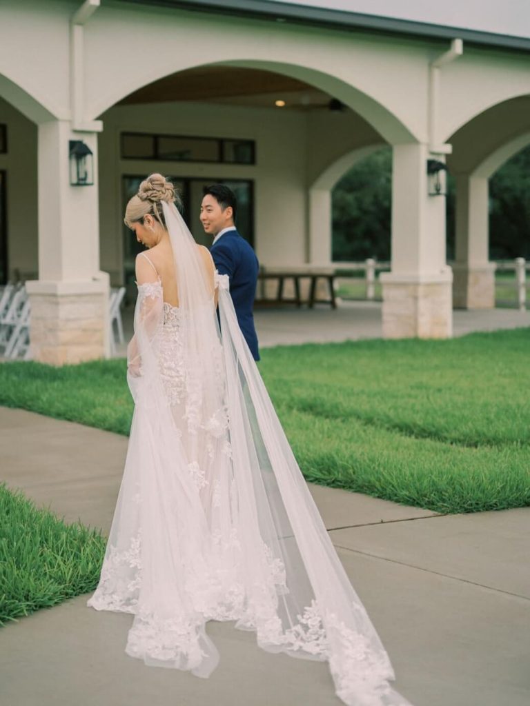The groom is walking towards the wedding venue with his bride.