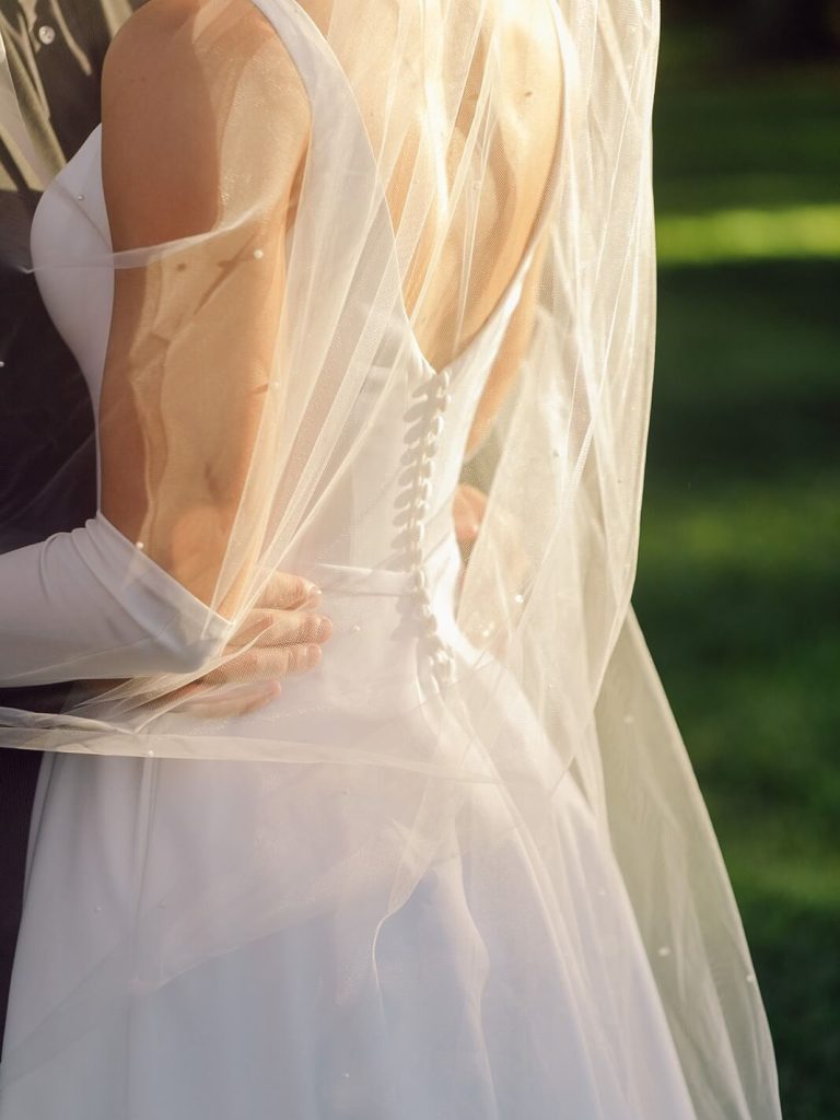 A showcase of a wedding dress's back details with its soft satin and button-up closing.