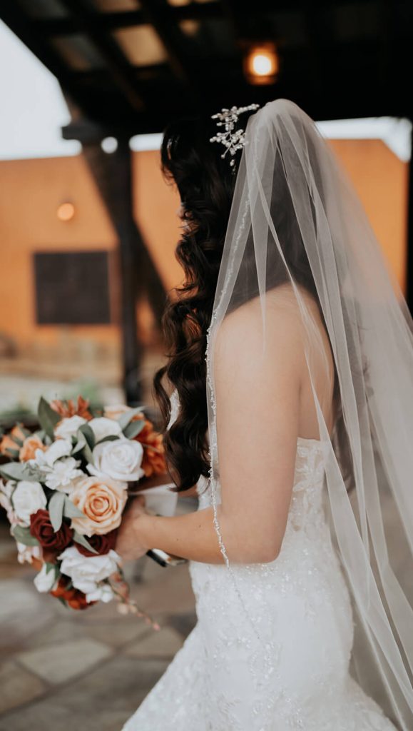 The side of a bride holding her bouquet while walking.
