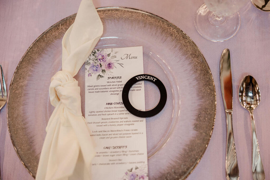 A table setting with an elegant plate, silverware, a menu, and a white napkin.
